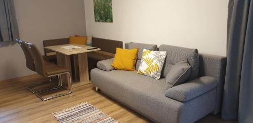 uma sala de estar com um sofá e uma cadeira em Pension Haus Christl em Kitzbühel