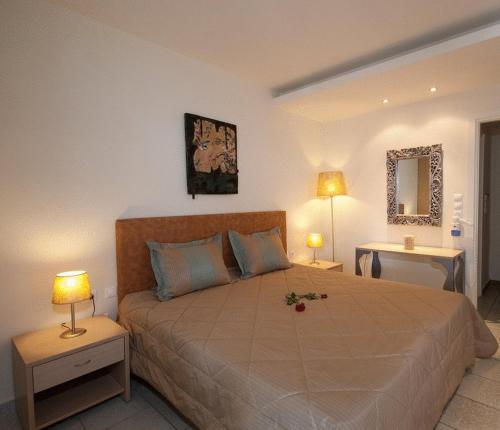a bedroom with a large bed with two lamps at Venus Beach Hotel in Nea Stira