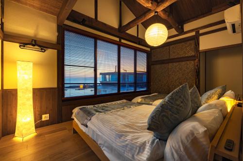 um quarto com uma cama grande e uma janela grande em StellaStoria HAYAMA Seaside house with open-air bath em Hayama