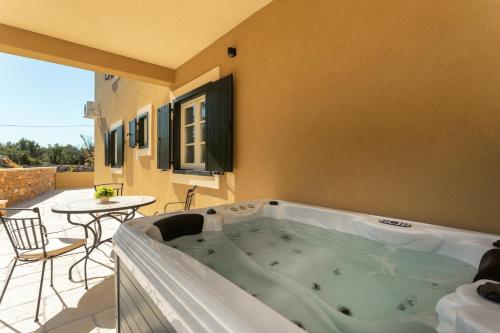 a jacuzzi tub on the patio of a house at TEONA Luxury Studio Apartment with jacuzzi and garden view in Sali