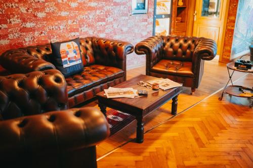 a living room with two leather couches and a coffee table at Dooscht Gästehaus Reichshof in Kröv