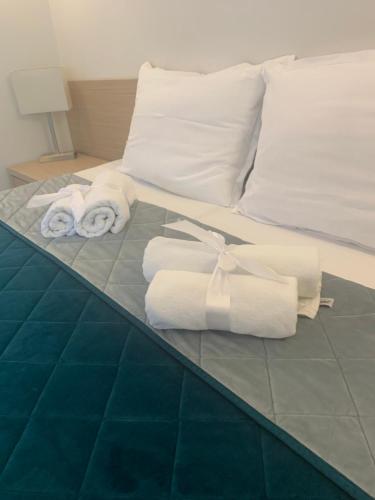 Una cama con toallas y almohadas. en Garni hotel Vir, en Vrnjačka Banja