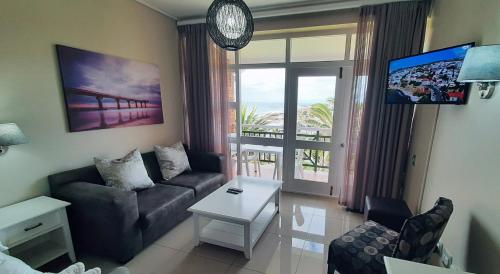 - un salon avec un canapé et une vue sur l'océan dans l'établissement Blue views at Brookes Hill Suites, à Port Elizabeth