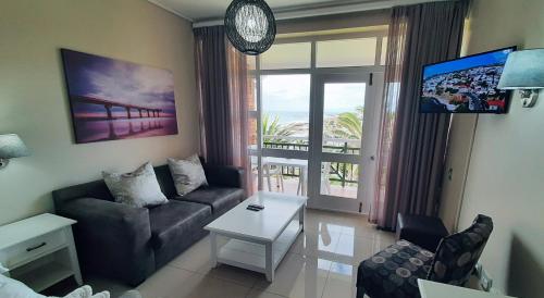 a living room with a couch and a view of the ocean at Blue views at Brookes Hill Suites in Port Elizabeth