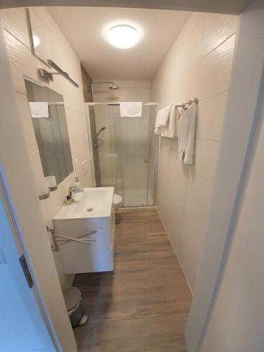 a white bathroom with a sink and a shower at Steinhauser`s Ferienwohnungen in Augsburg