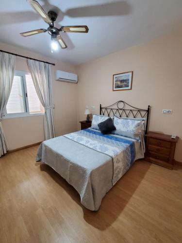 1 dormitorio con 1 cama y ventilador de techo en Duplex extraordinario naturista en Vera Playa!, en Vera
