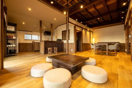 uma grande sala de estar com uma mesa e bancos em StellaStoria HAYAMA Seaside house with open-air bath em Hayama