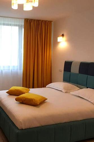 a bedroom with a large bed with two yellow pillows at BLISS Dubova in Dubova