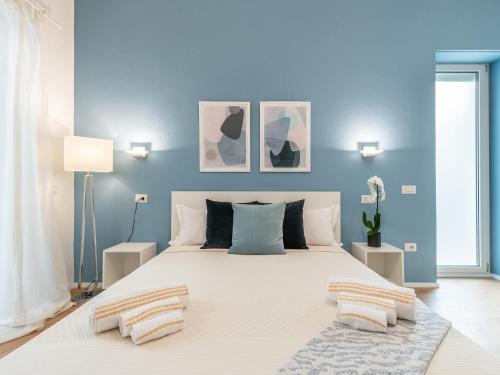 カリアリにあるAcquaChiara Suiteの青い壁のベッドルーム1室(大型ベッド1台付)