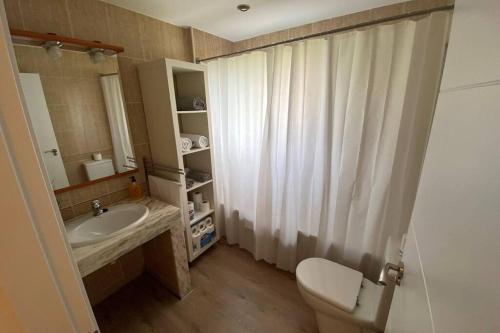a bathroom with a sink and a toilet and a mirror at APARTAMENTO ENTERO CON PISCINA A 5 MIN DEL CENTRO in Figueres