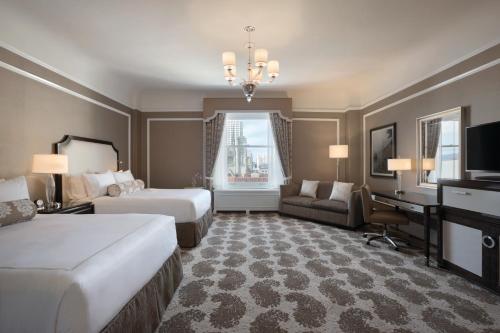 a hotel room with two beds and a desk at Fairmont San Francisco in San Francisco