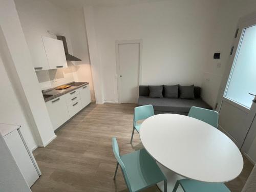 una mesa blanca y sillas en una habitación pequeña en Residence Wally Bilocale Piano Terra - Agenzia Cocal, en Caorle