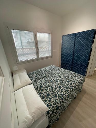 Residence Wally Bilocale Piano Terra - Agenzia Cocal في كاورلي: غرفة نوم صغيرة بها سرير ونوافذ