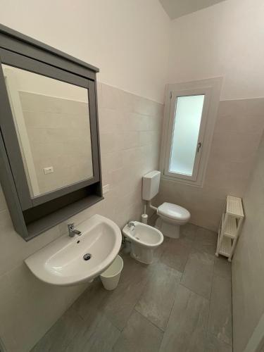 Residence Wally Bilocale Piano Terra - Agenzia Cocal في كاورلي: حمام مع حوض ومرحاض ومرآة