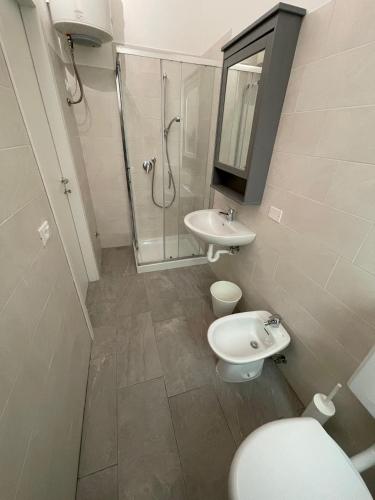 y baño con aseo, lavabo y ducha. en Residence Wally Bilocale Piano Terra - Agenzia Cocal, en Caorle