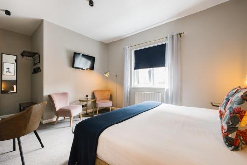 a bedroom with a bed and a desk and a window at CitySpace Borough in London