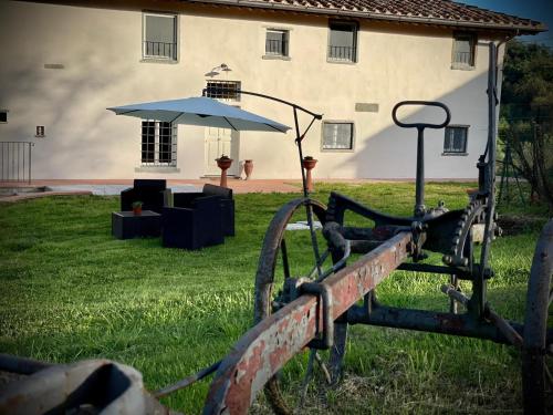 an old fence with an umbrella in front of a house at La valle B&B in Cavriglia