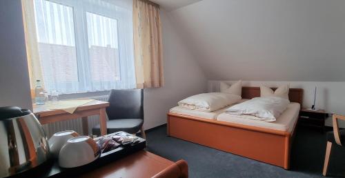 a small room with a bed and a desk and a desk at Hotel Seehalde in Nonnenhorn
