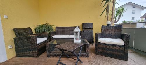 a patio with wicker chairs and a table with a table at Hotel Seehalde in Nonnenhorn