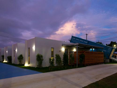 a white building with a blue sign on it at Painushima Resort in Ishigaki Island