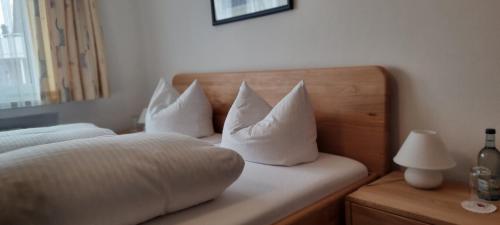 a bedroom with a bed with white pillows at Hotel Seehalde in Nonnenhorn