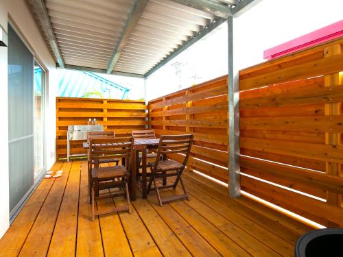 a dining room with a table and chairs on a wooden deck at Painushima Resort in Ishigaki Island