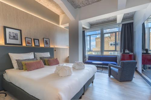 sypialnia z dużym łóżkiem i niebieskim krzesłem w obiekcie Postillion Hotel WTC Rotterdam w Rotterdamie