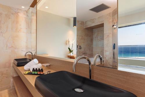 bagno con lavandino nero e specchio di Cactus Hotel a Città di Rodi