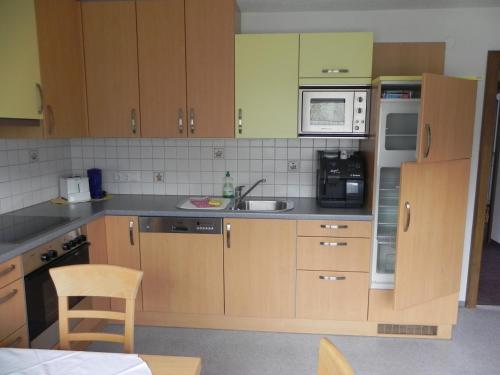 a kitchen with wooden cabinets and a sink at Ferienwohnung Schautzgy in Reutte