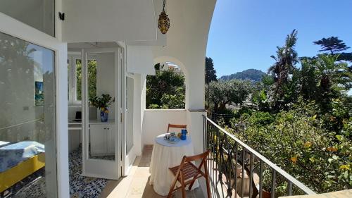 a balcony of a house with a table and chairs at Villa Dorothee in Capri