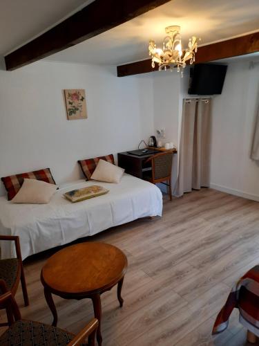 a room with a bed and a table and a desk at Auberge du Gros Tilleul in Argoules