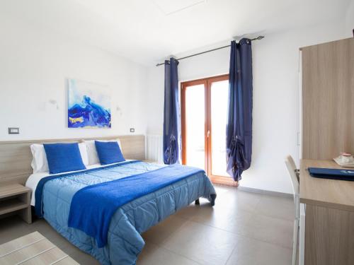 a bedroom with a bed and a desk and a window at Navicri B&B in Vieste