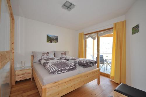 a bedroom with a bed and a balcony at Buorcha in Scuol