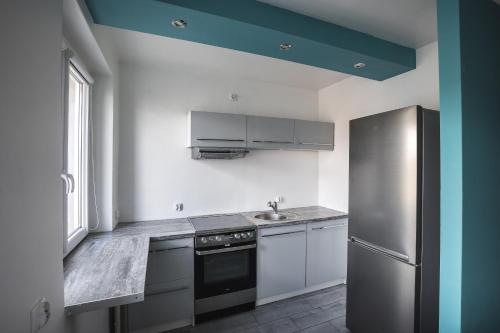 een keuken met een koelkast en een wastafel bij High Floor Vision Apartment in Opole