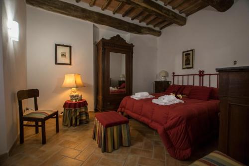 a bedroom with a red bed and a mirror at Dimora Tipica Toscana in Monticiano