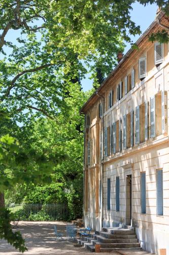 an old building with blue benches in front of it at Chateau de Saint Martin in Taradeau