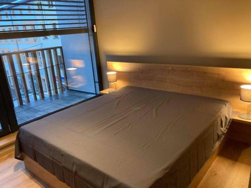 Cama en habitación con ventana grande en Apartmán T5 Herlíkovice, en Vrchlabí