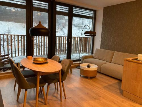 a living room with a table and a couch at Apartmán T5 Herlíkovice in Vrchlabí