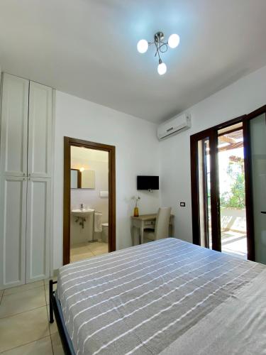 a white bedroom with a bed and a bathroom at Villa Elia - Tenuta Le Scerze - Salento Homes in Borgagne