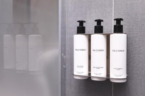 a group of three white bottles on a wall at Hotel Veronesi La Torre in Dossobuono