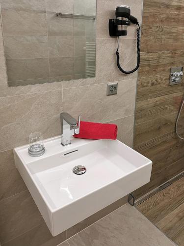 a white bathroom sink with a red towel on it at Appartement Flora in Saas-Almagell