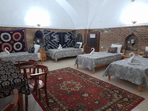 a room with four beds and a brick wall at Caravan Sarai Yotoqxona in Khiva