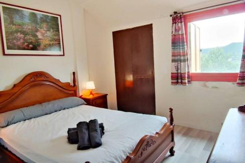 une chambre avec un lit avec deux chaussures dessus dans l'établissement APARTAMENTO SOLANO - VIRGEN DE LA VEGA - ALCALÁ IDEAL MONTAñA Y RELAX, à Teruel