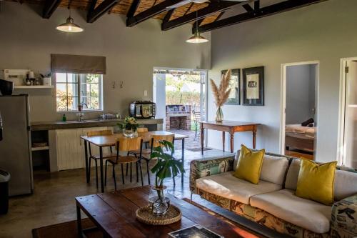 a living room with a couch and a table at Saronsberg Vineyard Cottages in Tulbagh