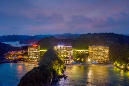 a city lit up at night next to the water at Flamingo Premium Lan Ha Bay Resort in Hai Phong