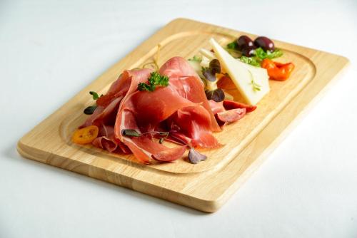 a plate of food with meat and cheese on a cutting board at Vila White in Trogir