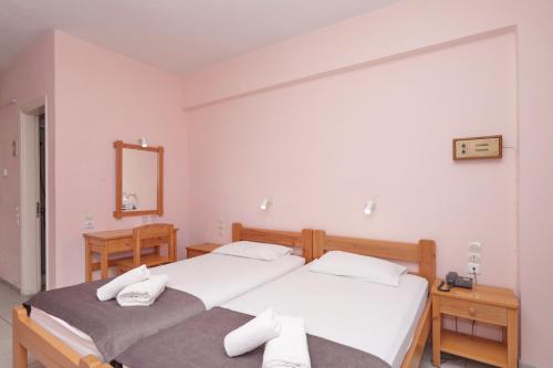 a bedroom with two beds with towels on them at Dolphin Hotel in Skopelos Town