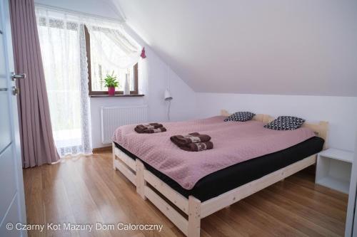 a bedroom with a bed with a purple blanket at Czarny Kot Mazury Dom Całoroczny in Małkinie