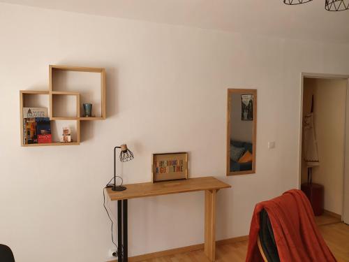 a room with a wooden table and a mirror at Les Petites Fontaines au cœur de la Doutre in Angers