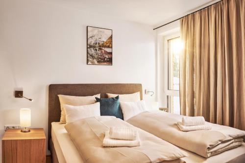 - une chambre avec un grand lit et une fenêtre dans l'établissement Adler Lodge D2 by AA Holiday Homes, à Tauplitz